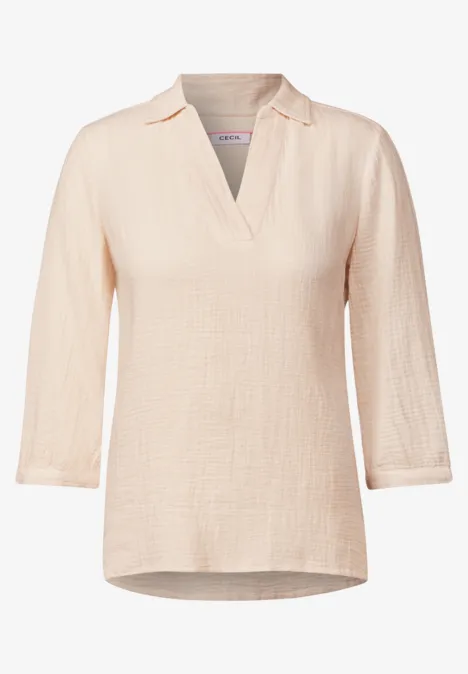Hellbeige Bluse mit 3/4-Ärmeln und V-Ausschnitt.